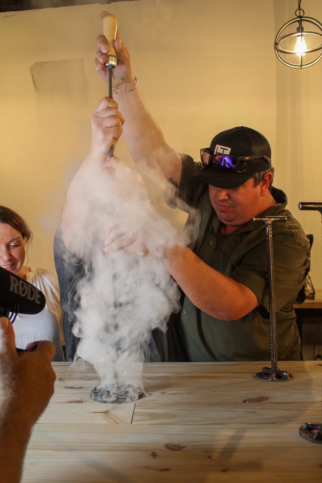 Smoke rising as a branding iron marks the wooden bar